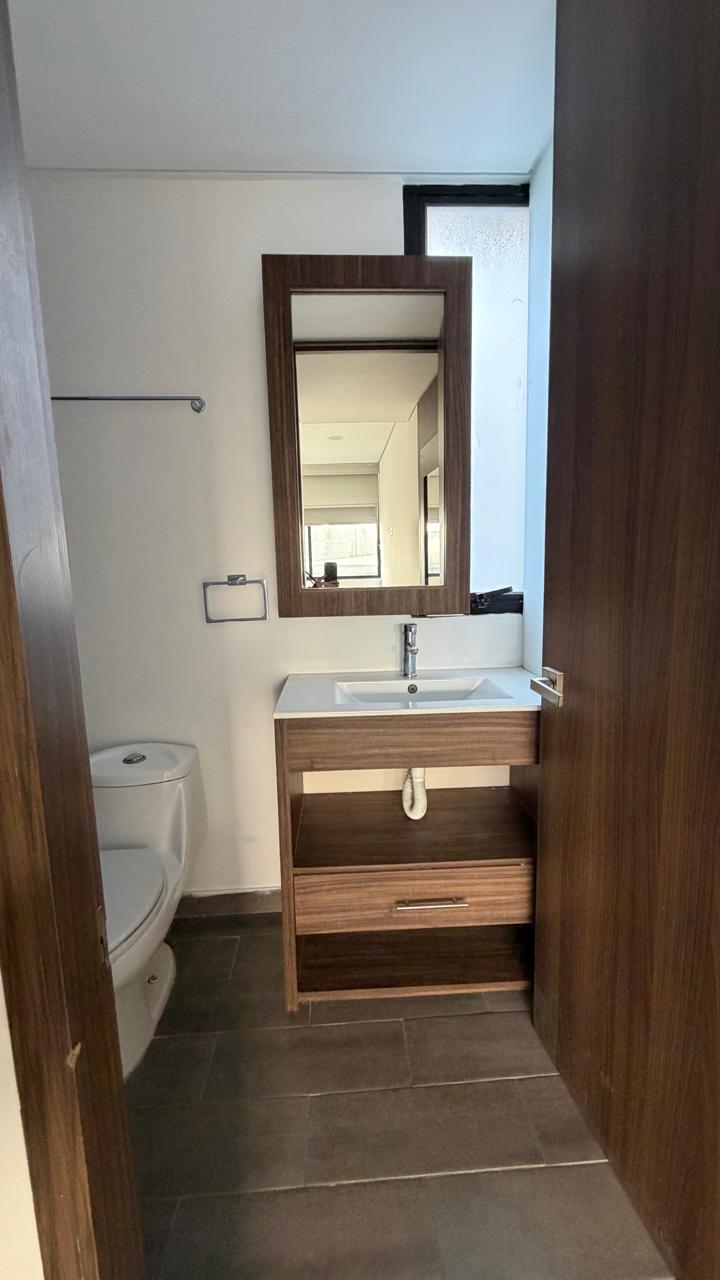 Baño completo con mueble de madera y espejo