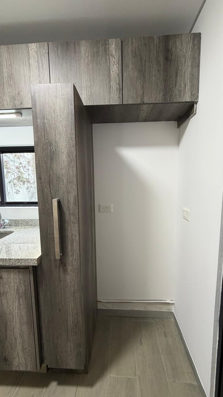 Área de lavado con alacena de madera y espacio para electrodomésticos