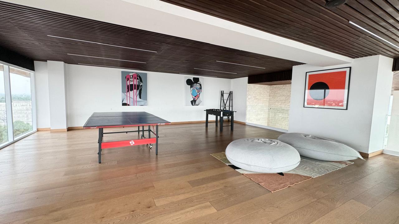 Sala de juegos con mesa de ping pong y futbolito