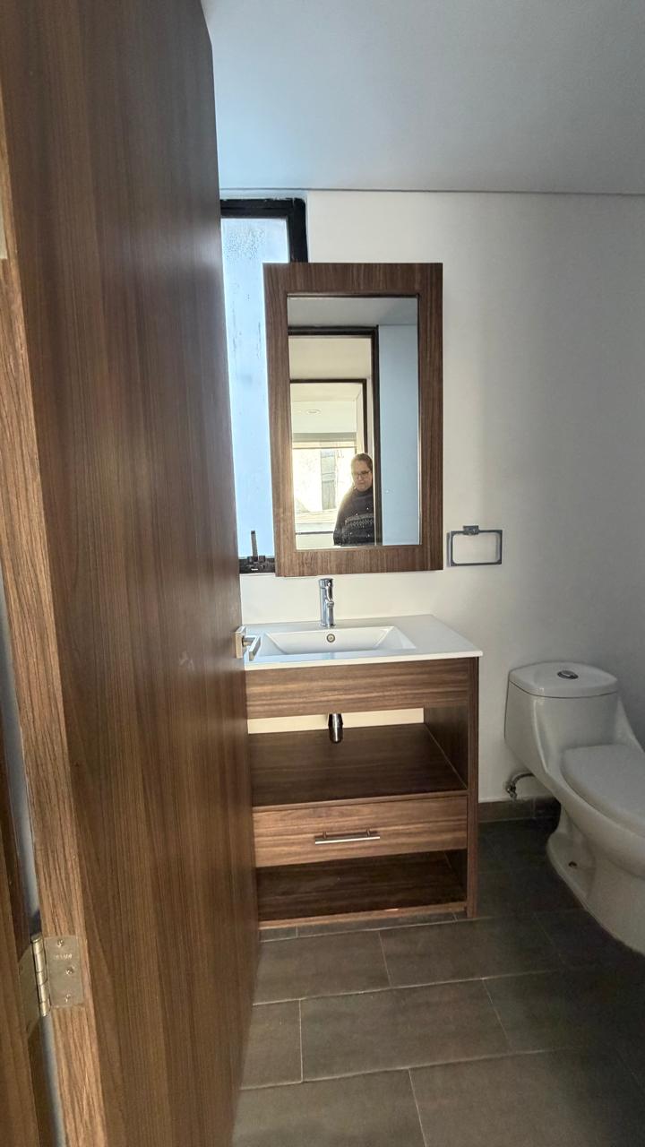 Baño con lavabo, mueble de madera y espejo
