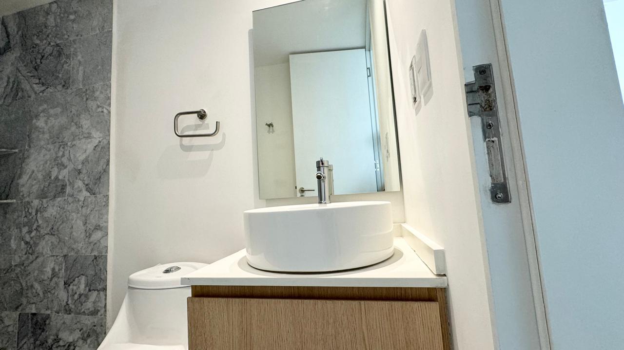 Medio baño con lavabo de sobreponer y muro de mármol