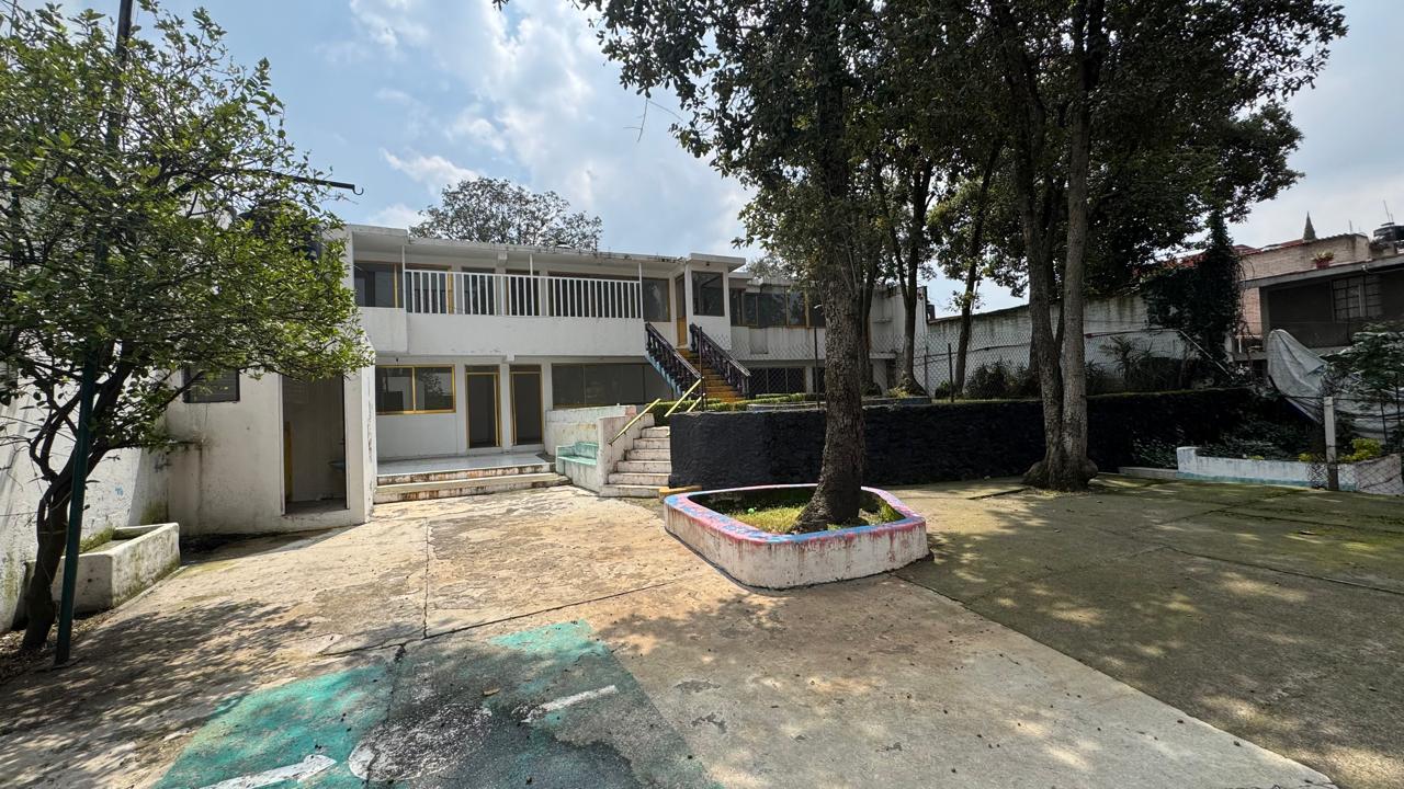Fachada del inmueble con patio amplio y árboles