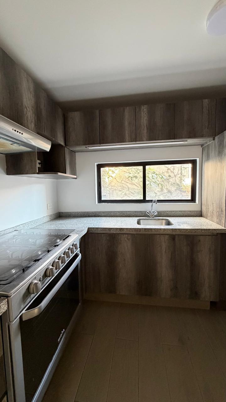 Cocina con ventana, tarja y cubierta de granito