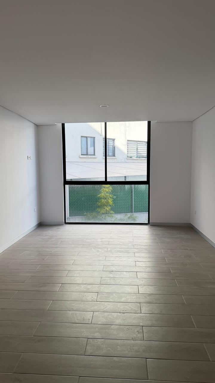 Sala del departamento con ventanal de piso a techo